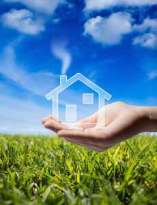 buy home - Icon house in the hand - grass and sky